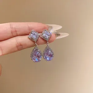 Élégantes boucles d'oreilles pendantes en zircon violet avec des halos de cristaux fins