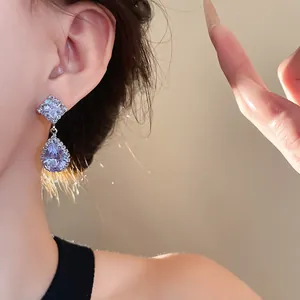 Gros plan élégant d'une boucle d'oreille en argent avec zircones en forme de goutte d'eau