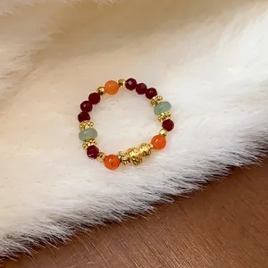 Macro di un anello elastico con perline colorate e dettagli dorati su pelliccia bianca sintetica