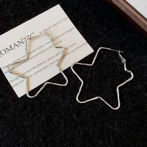 Primer plano detallado de aretes de aro con forma de estrella en tela negra.