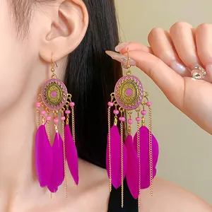 Boho-Ohrringe im Ethno-Stil mit fuchsiafarbenen Federn und detailliertem Öltropfen-Design.
