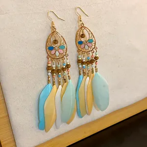 Detailansicht der Boho-Ohrringe mit bunten Federn und wunderschönen Emaille-Blumen.
