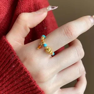 Primo piano di un anello elastico fatto a mano con perle turchesi e occhio di tigre
