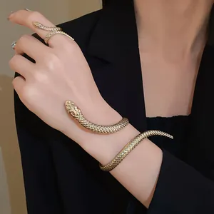 Detailed macro view of gold snake-shaped bracelet and ring set with realistic scale textures