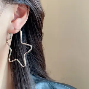 Primer plano de un pendiente de aro con forma de estrella plateada para un look actual.