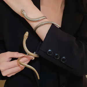 Detail shot of elegant gold and silver snake-shaped twisted open bracelets on model