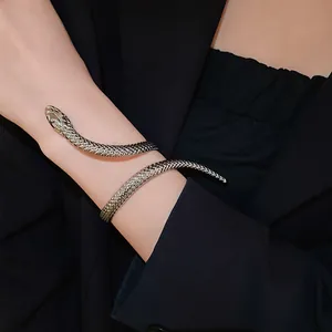Close-up of a silver twisted snake open bracelet featuring detailed scale texture on a wrist.