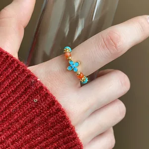 Dettaglio ravvicinato di un anello elastico con perline, occhio di tigre e trifoglio