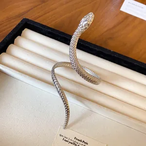 Detailed view of a silver textured snake wrap bangle on a jewelry display tray.