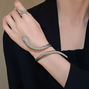 Detail of silver twisted snake-shaped wrap bracelet and matching ring on model's hand