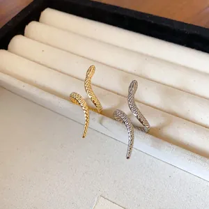 Detailed view of gold and silver snake bracelets with scale texture on jewelry tray.