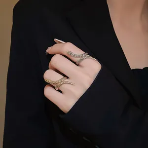 Detailed view of elegant gold and silver textured snake wrap rings on model's hand