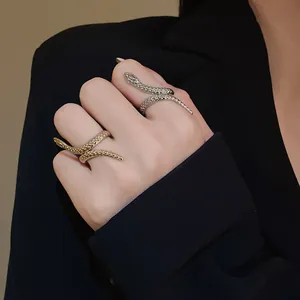 Macro view of textured adjustable snake-shaped rings in gold and silver metal finish.