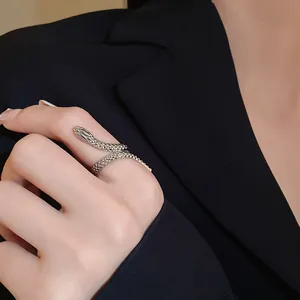 Close-up of silver snake wrap ring with detailed scale texture on model's finger