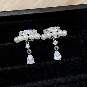 Macro view of French style pearl ear clips with sparkling zircon waterdrop pendants