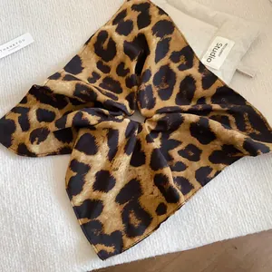 Dettaglio dell'elastico per capelli in tessuto leopardato retrò con design quadrato pieghettato