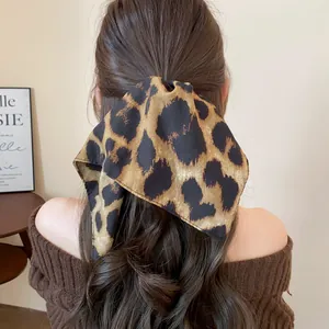 Elegante elastico per capelli in tessuto leopardato su una coda di cavallo, vista posteriore