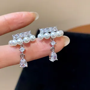 Close-up detail of elegant silver teardrop zircon and pearl ear clips for non-pierced ears