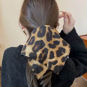 Primo piano di un elastico per capelli in tessuto con stampa leopardata su una coda