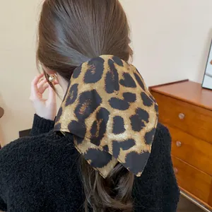 Dettaglio di un elastico per capelli in tessuto leopardato vintage per una coda di cavallo.