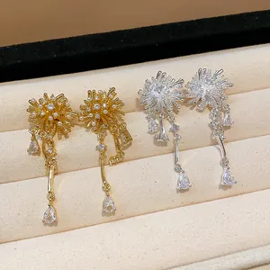 Close-up of gold and silver firework earrings with sparkling drop zircons in a jewelry box