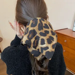 Vista dettagliata di uno scrunchie vintage in tessuto leopardato su una coda di cavallo.