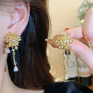Detailed macro shot of 18k gold plated firework earrings featuring zircons and pearls