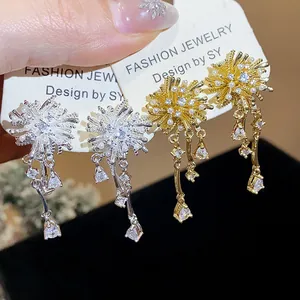 Close-up of 18k gold plated zircon fireworks earrings with sparkling tassels