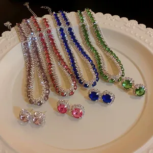 Sparkling square gemstone necklace and earring set in four vibrant colors displayed on a plate