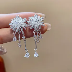 Close-up of silver starburst earrings with sparkling zircon dangles and pearls