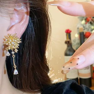 Close-up of 18k gold-plated firework earrings with sparkling zircon dangles.