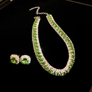 Close-up of emerald green jewelry set with necklace and earrings on black background