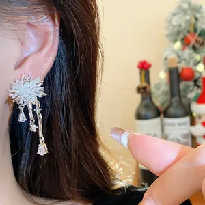 Detailed close-up showing 18k gold plated zircon firework dangle earrings worn on ear