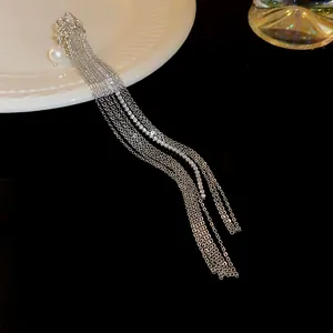 Detail view of long tassel ear cuff with shimmering rhinestones and a white pearl
