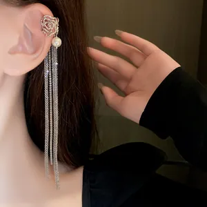 Detail shot of elegant silver rose ear cuff featuring long rhinestone pearl tassels