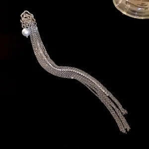 Detailed shot of a silver tassel ear cuff with pearl and shimmering rhinestones
