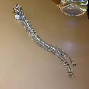 Detailed view of elegant silver tassel ear cuff featuring a pearl and sparkling rhinestones.