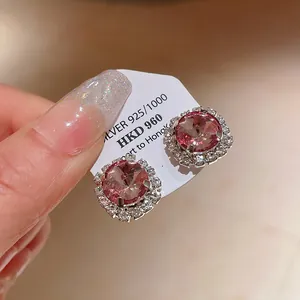 Detailed close-up of elegant pink crystal floral stud earrings on a display card
