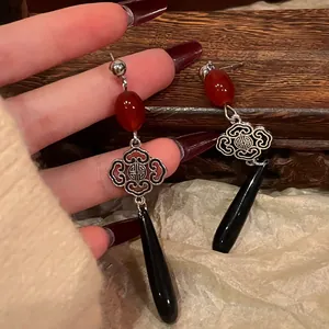 Detailed macro view of New Chinese style earrings with Chinese knot and black teardrop