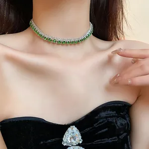 Elegant silver choker necklace with emerald-cut green crystals worn by model on neck.