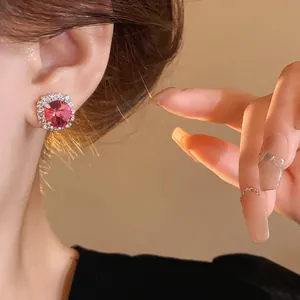 Elegant round pink crystal halo stud earrings worn by model, luxury sparkling jewelry accessory