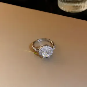 Gros plan d'une bague ouverte en argent de luxe avec un grand zircon et double halo