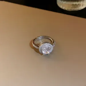 Bague ouverte élégante en argent avec halo de zircones et une pierre centrale brillante