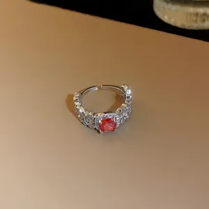 Vue détaillée d'une bague de luxe avec zircon rouge et motif en écailles de dragon.