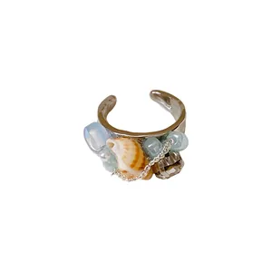 Anello regolabile stile oceano con una conchiglia naturale, perle blu e zirconi.