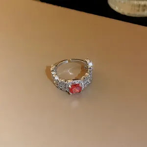 Vue macro d'une bague ouverte argentée ornée d'un zircon carré rouge éclatant au centre