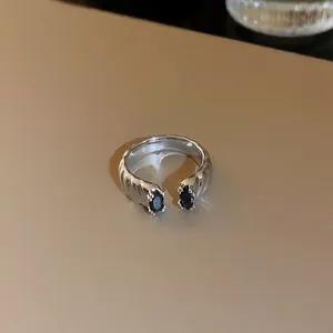 Vue détaillée d'une bague ouverte en écailles de dragon argentée avec des zircons noirs