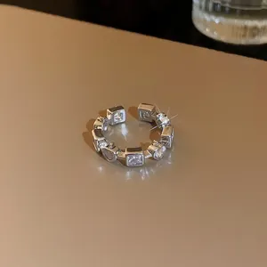 Détail d'une bague ouverte en argent sertie de zircons en forme de cœur et carrés
