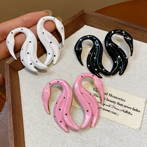 Elegantes pendientes con forma de cisne en esmalte con lunares en blanco, negro y rosa.