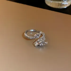 Vue détaillée d'une bague dragon en argent avec pavé de zircons et yeux en pierre rouge.